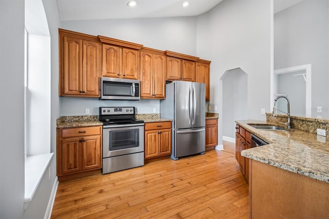 309 Crystal Lake Dr, Saint Augustine, FL 32084 - kitchen featuring light stone counters, light wood-style flooring, stainless steel appliances, and a sink