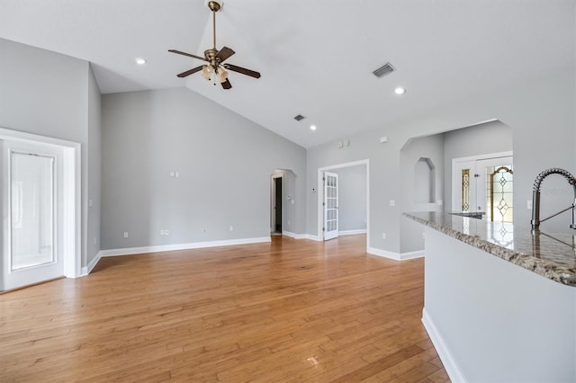 309 Crystal Lake Dr, Saint Augustine, FL 32084 - unfurnished living room featuring visible vents, high vaulted ceiling, light wood-style flooring, a ceiling fan, and arched walkways