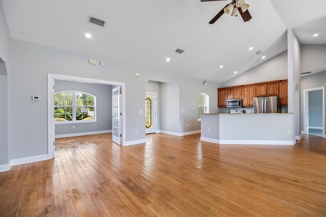 309 Crystal Lake Dr, Saint Augustine, FL 32084 - unfurnished living room with light wood-type flooring, visible vents, high vaulted ceiling, a ceiling fan, and arched walkways