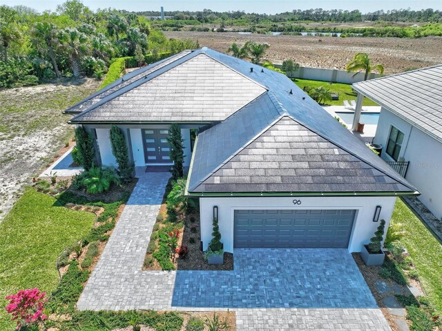 96 Del Palma Dr, Palm Coast, FL 32137 - view of front of house with stucco siding, roof with shingles, french doors, driveway, and a garage
