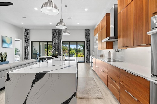 96 Del Palma Dr, Palm Coast, FL 32137 - kitchen featuring black electric cooktop, wall chimney exhaust hood, a spacious island, modern cabinets, and brown cabinets