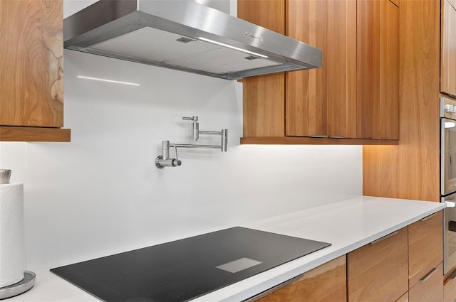 96 Del Palma Dr, Palm Coast, FL 32137 - kitchen featuring modern cabinets, light countertops, brown cabinetry, and range hood