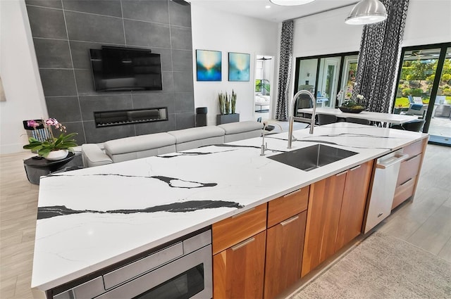 96 Del Palma Dr, Palm Coast, FL 32137 - kitchen featuring modern cabinets, light stone countertops, brown cabinets, a sink, and open floor plan