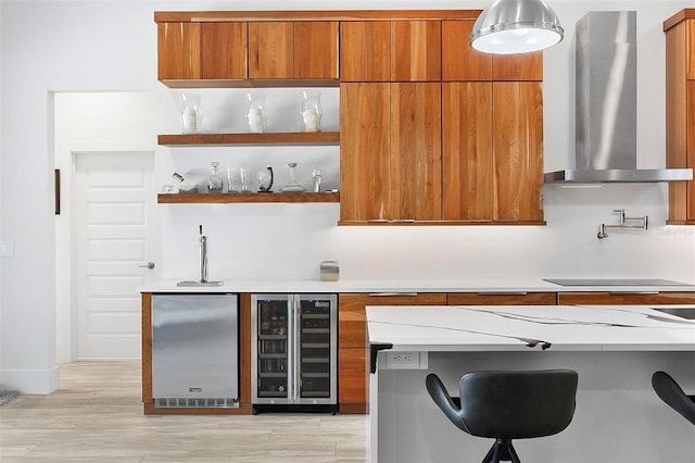 96 Del Palma Dr, Palm Coast, FL 32137 - kitchen with stainless steel refrigerator, black electric cooktop, wine cooler, brown cabinetry, and wall chimney exhaust hood