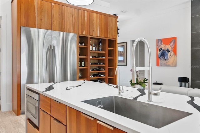 96 Del Palma Dr, Palm Coast, FL 32137 - kitchen featuring a sink, brown cabinets, light stone counters, and appliances with stainless steel finishes