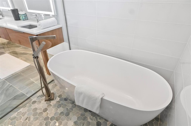 96 Del Palma Dr, Palm Coast, FL 32137 - full bathroom with tile walls, a soaking tub, double vanity, tile patterned floors, and a sink