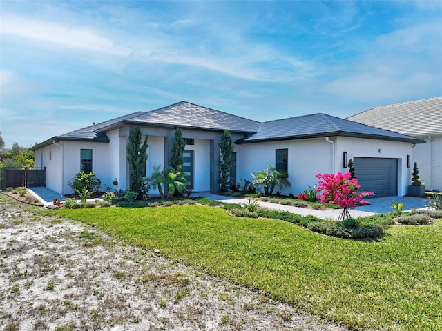 96 Del Palma Dr, Palm Coast, FL 32137 - prairie-style home with stucco siding, an attached garage, and a front yard