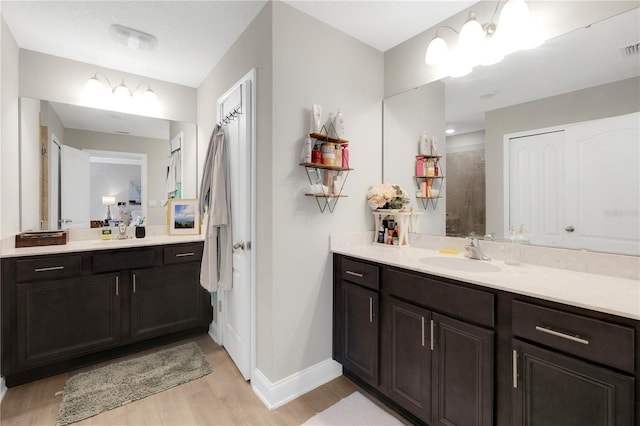 49 Narvarez Ave, Saint Augustine, FL 32084 - bathroom featuring baseboards, wood finished floors, vanity, and tiled shower