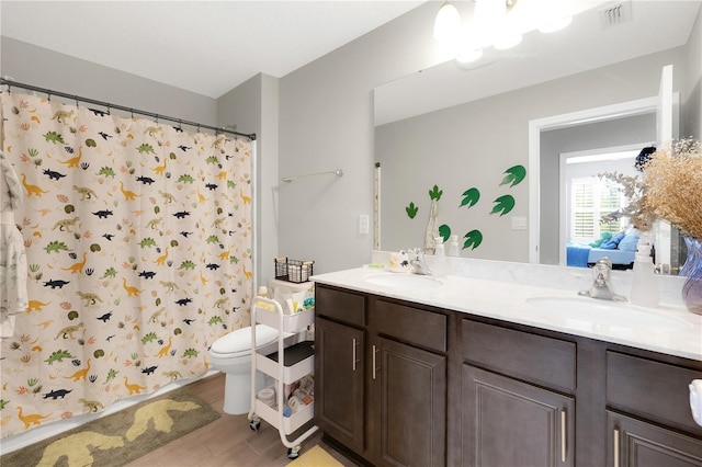 49 Narvarez Ave, Saint Augustine, FL 32084 - full bathroom featuring double vanity, toilet, wood finished floors, and a shower with shower curtain