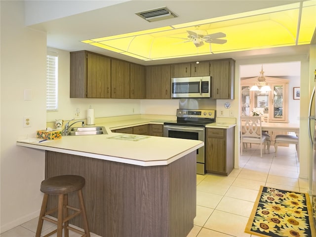 41 Oxford Ln Unit 41, Palm Coast, FL 32137 - kitchen with a peninsula, light countertops, light tile patterned flooring, visible vents, and stainless steel appliances