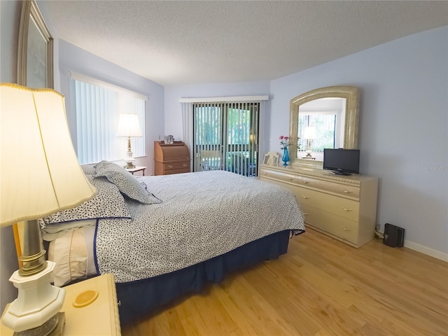 41 Oxford Ln Unit 41, Palm Coast, FL 32137 - bedroom with baseboards, light wood-type flooring, and a textured ceiling
