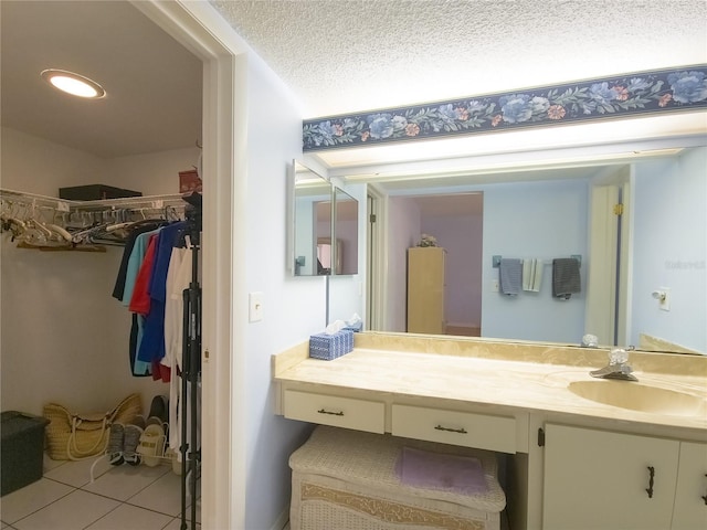 41 Oxford Ln Unit 41, Palm Coast, FL 32137 - bathroom with vanity, a spacious closet, tile patterned flooring, recessed lighting, and a textured ceiling