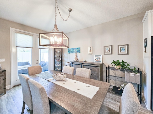68 Los Lagos Blvd, Palm Coast, FL 32137 - dining area with a chandelier, light wood finished floors, baseboards, and french doors