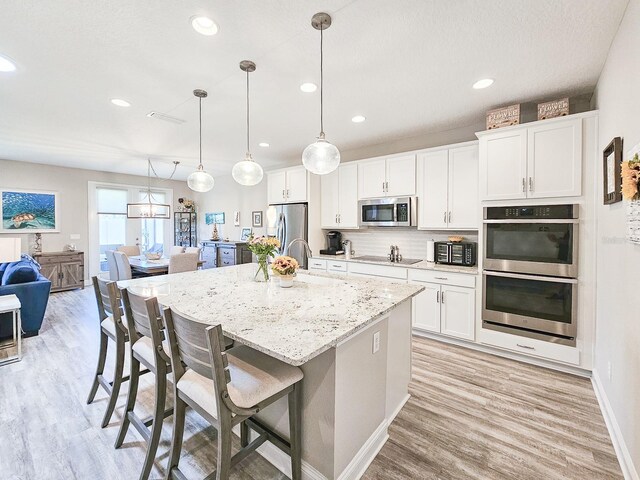 68 Los Lagos Blvd, Palm Coast, FL 32137 - kitchen with appliances with stainless steel finishes, a sink, light wood-type flooring, a center island with sink, and recessed lighting