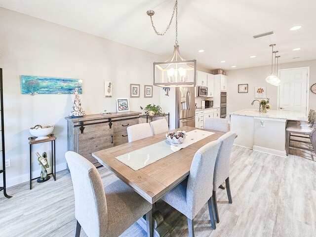 68 Los Lagos Blvd, Palm Coast, FL 32137 - dining room with light wood-style flooring, baseboards, recessed lighting, and a chandelier