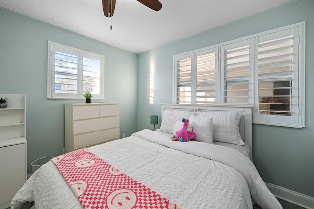 bedroom with baseboards, ceiling fan, and a textured ceiling