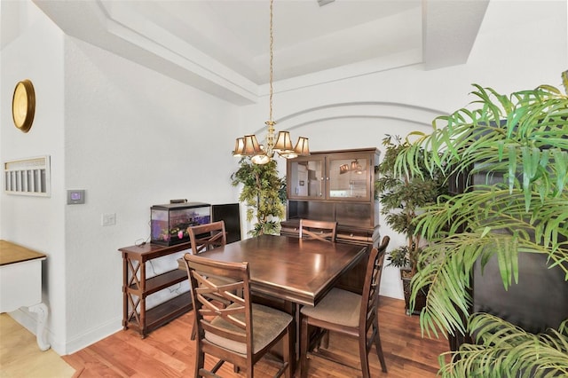 3220 Galty Cir, Ormond Beach, FL 32174 - dining room featuring light wood-style floors, a raised ceiling, baseboards, and a chandelier