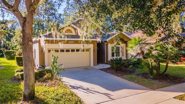 3220 Galty Cir, Ormond Beach, FL 32174 - view of property hidden behind natural elements featuring concrete driveway, stucco siding, and an attached garage