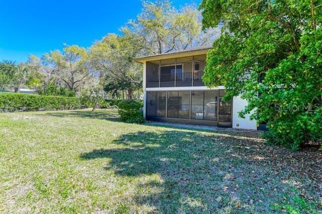 31 Catalonia Court E, Saint Augustine, FL 32086 - back of property with a sunroom and a lawn