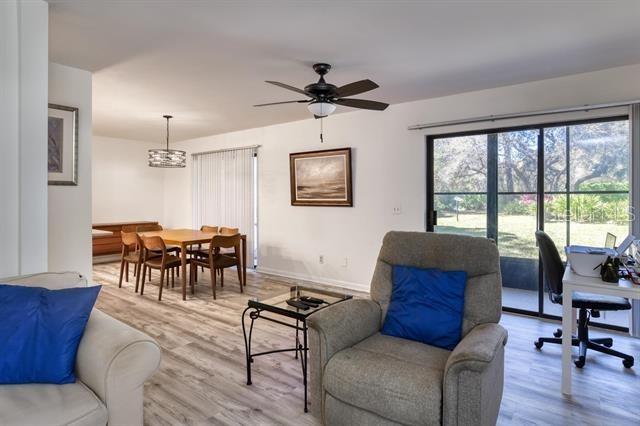 31 Catalonia Court E, Saint Augustine, FL 32086 - living area with light wood-type flooring, ceiling fan with notable chandelier, and baseboards
