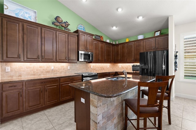 1316 Harwick Ln, Ormond Beach, FL 32174 - kitchen with appliances with stainless steel finishes, light tile patterned floors, a sink, tasteful backsplash, and a breakfast bar