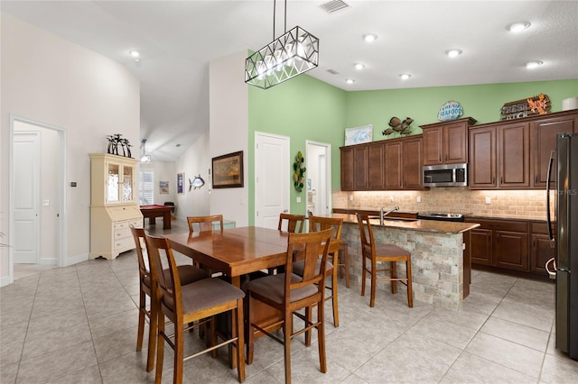 1316 Harwick Ln, Ormond Beach, FL 32174 - dining space featuring high vaulted ceiling, light tile patterned floors, and baseboards
