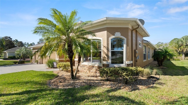 1316 Harwick Ln, Ormond Beach, FL 32174 - view of front of house featuring stucco siding, a front lawn, concrete driveway, and an attached garage