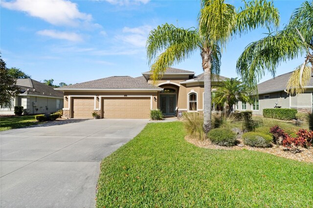 1316 Harwick Ln, Ormond Beach, FL 32174 - view of front facade featuring driveway, a front lawn, an attached garage, and stucco siding