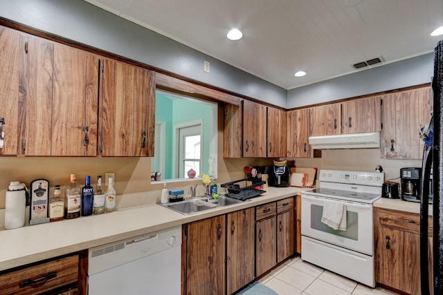 9 Shadow Ln, Ormond Beach, FL 32174 - kitchen with white appliances, under cabinet range hood, a sink, brown cabinetry, and light countertops