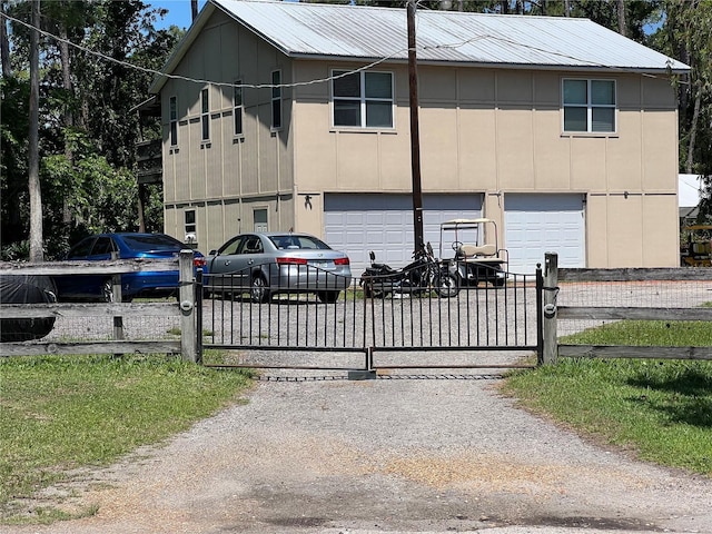 9 Shadow Ln, Ormond Beach, FL 32174 - view of front of property with an attached garage, driveway, a gate, and board and batten siding