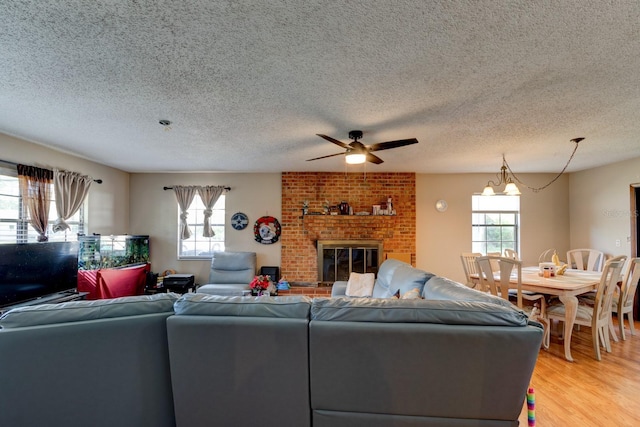 9 Shadow Ln, Ormond Beach, FL 32174 - living area with healthy amount of natural light, a textured ceiling, ceiling fan, light wood-type flooring, and a brick fireplace