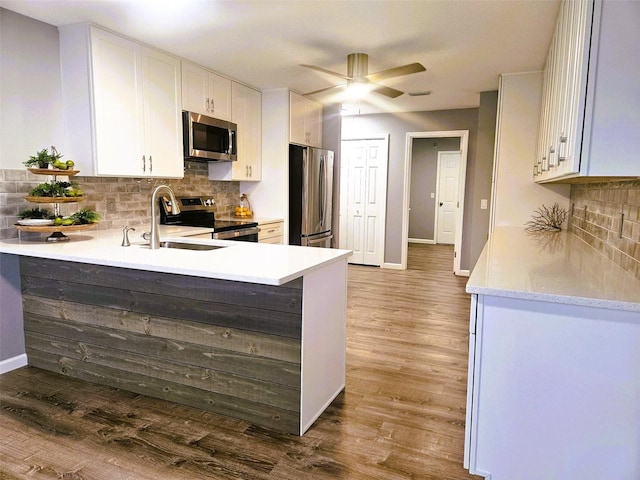 11 Cheyenne Ct, Palm Coast, FL 32137 - kitchen featuring appliances with stainless steel finishes, light countertops, wood finished floors, a ceiling fan, and baseboards