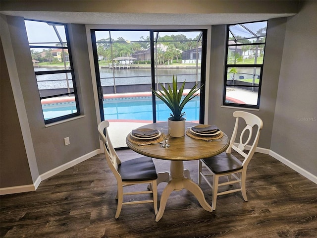 11 Cheyenne Ct, Palm Coast, FL 32137 - dining space with baseboards, a water view, and dark wood-type flooring