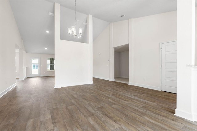 48 Sedgwick Trl, Palm Coast, FL 32164 - empty room with high vaulted ceiling, baseboards, a chandelier, and wood finished floors