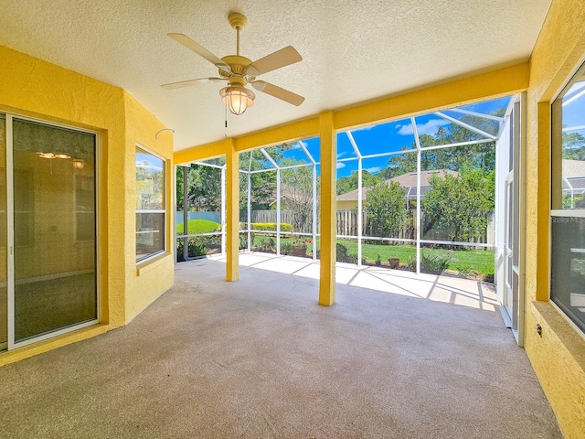 unfurnished sunroom featuring a ceiling fan