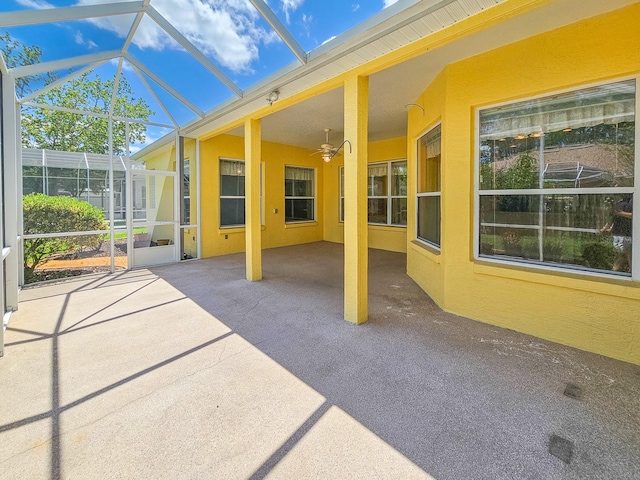 unfurnished sunroom featuring ceiling fan