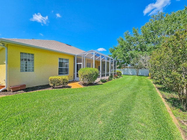 view of yard featuring a lanai and fence
