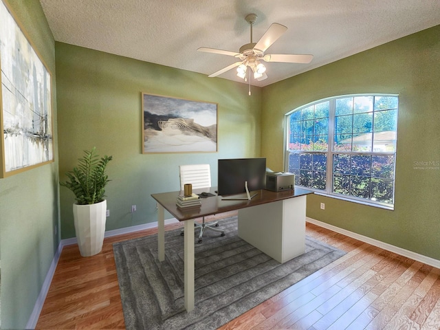 home office featuring a textured ceiling, ceiling fan, and wood finished floors
