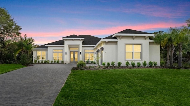29 Old Oak Dr S, Palm Coast, FL 32137 - view of front of home with french doors, stucco siding, a shingled roof, decorative driveway, and a yard