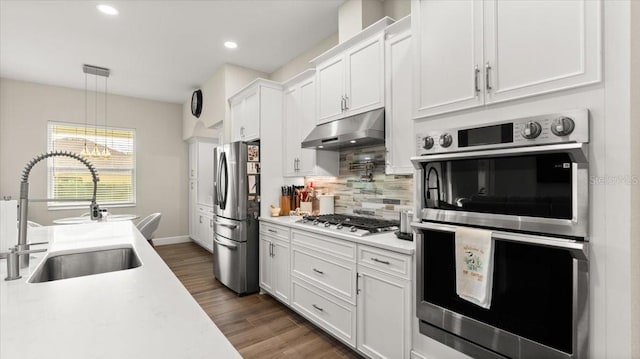 29 Old Oak Dr S, Palm Coast, FL 32137 - kitchen with light countertops, stainless steel appliances, under cabinet range hood, white cabinetry, and a sink
