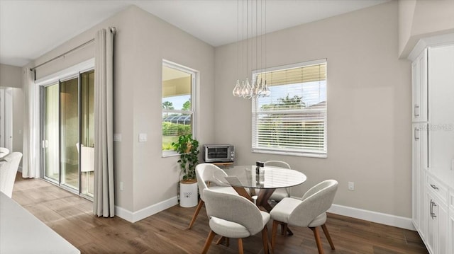 29 Old Oak Dr S, Palm Coast, FL 32137 - dining space featuring an inviting chandelier, baseboards, and wood finished floors