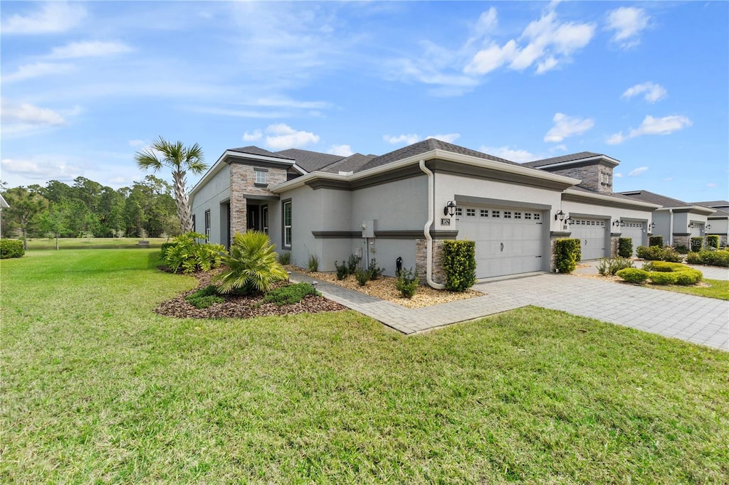 852 Pinewood Dr, Ormond Beach, FL 32174 - view of front of home featuring stucco siding, a garage, a front yard, and decorative driveway