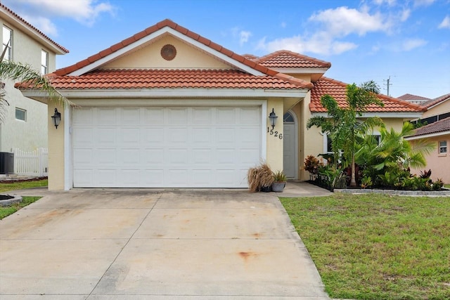 mediterranean / spanish-style home featuring stucco siding, an attached garage, a tiled roof, and concrete driveway