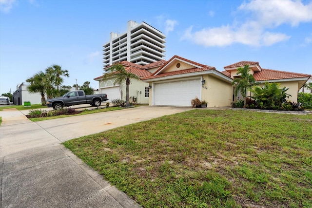 view of front of house with concrete driveway, stucco siding, a tiled roof, a front lawn, and a garage