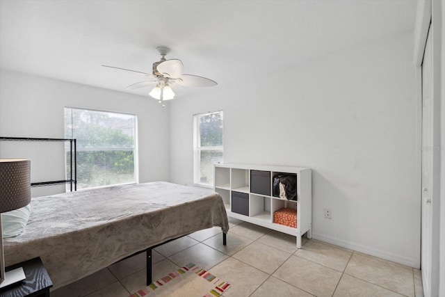 bedroom with a ceiling fan, tile patterned floors, and baseboards