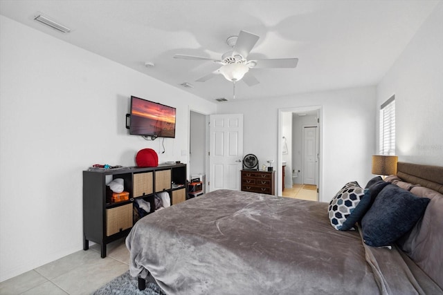 bedroom with light tile patterned flooring, connected bathroom, baseboards, visible vents, and ceiling fan