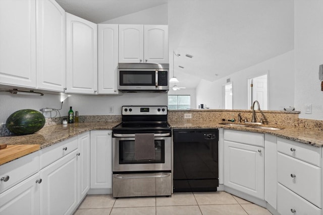 kitchen with light tile patterned flooring, light stone counters, a sink, lofted ceiling, and stainless steel appliances