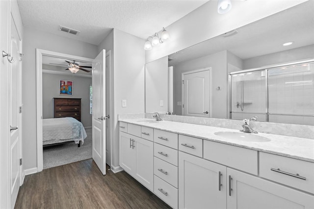 324 Palace Dr, Saint Augustine, FL 32084 - ensuite bathroom with double vanity, wood finished floors, a stall shower, ceiling fan, and a textured ceiling