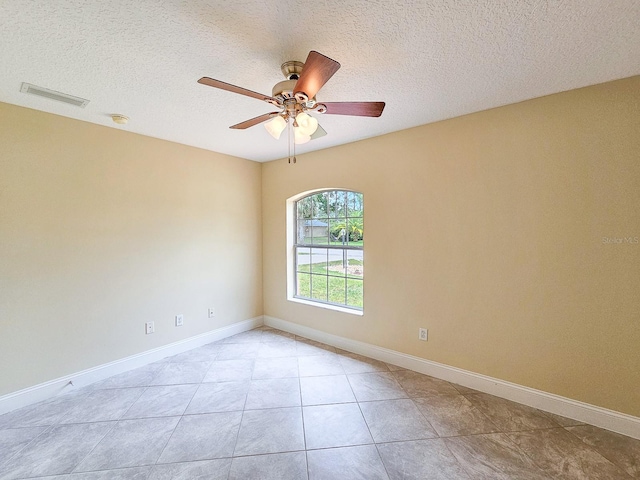18 Wheatfield Dr, Palm Coast, FL 32164 - empty room with a ceiling fan, a textured ceiling, baseboards, light tile patterned flooring, and a smoke detector