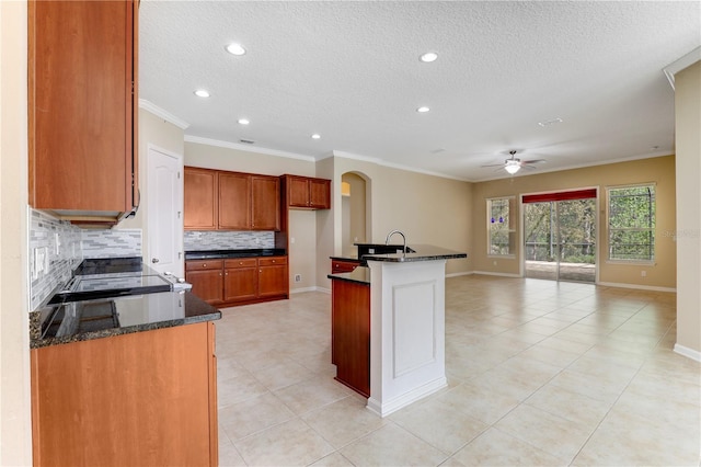 4484 Gray Hawk St, Orange Park, FL 32065 - kitchen featuring ceiling fan, ornamental molding, tasteful backsplash, dark stone countertops, and open floor plan